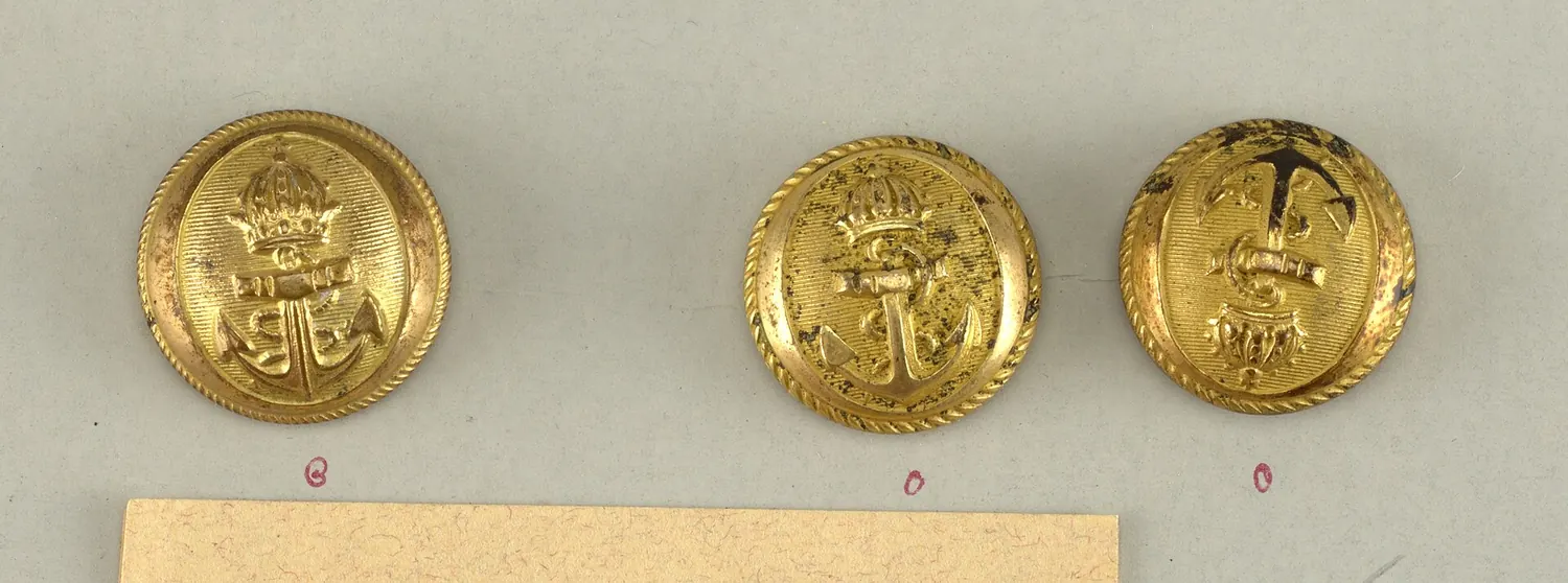 Three brass uniform buttons, each with an anchor in the centre